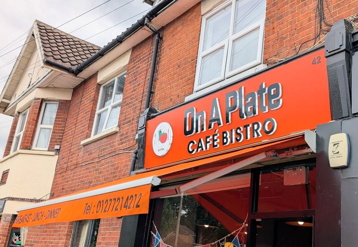 On A Plate's orange shopfront at 42 Hutton Road, with the café bistro sign and awning printed with the phone number